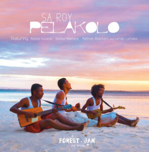 Sa Roy, 3 young Malagasi musicians sitting on the beach looking at the sunset playing guitars